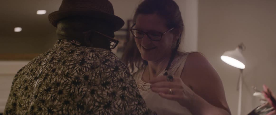 A couple dance in a living room
