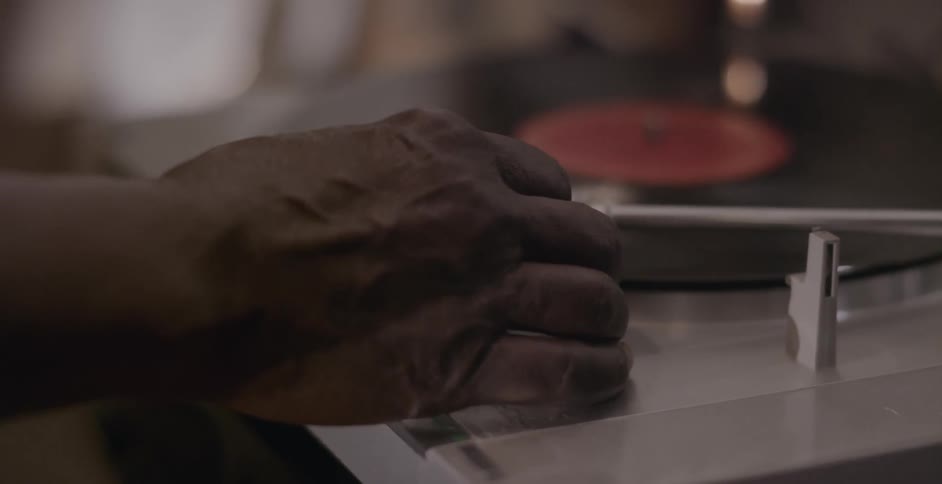 A man moves the needle on a record player