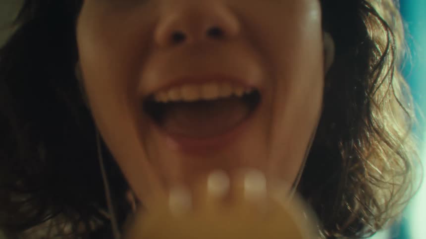 Smiling woman wears earphones while singing