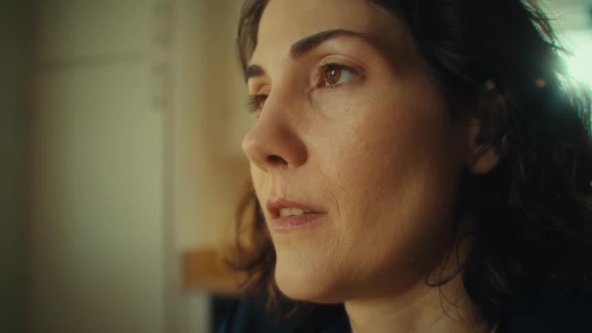 Thoughtful woman sitting in the kitchen