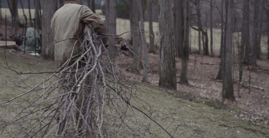 A man carries a bundle of sticks