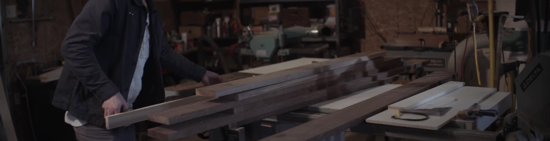 A man adjusts wood on a table