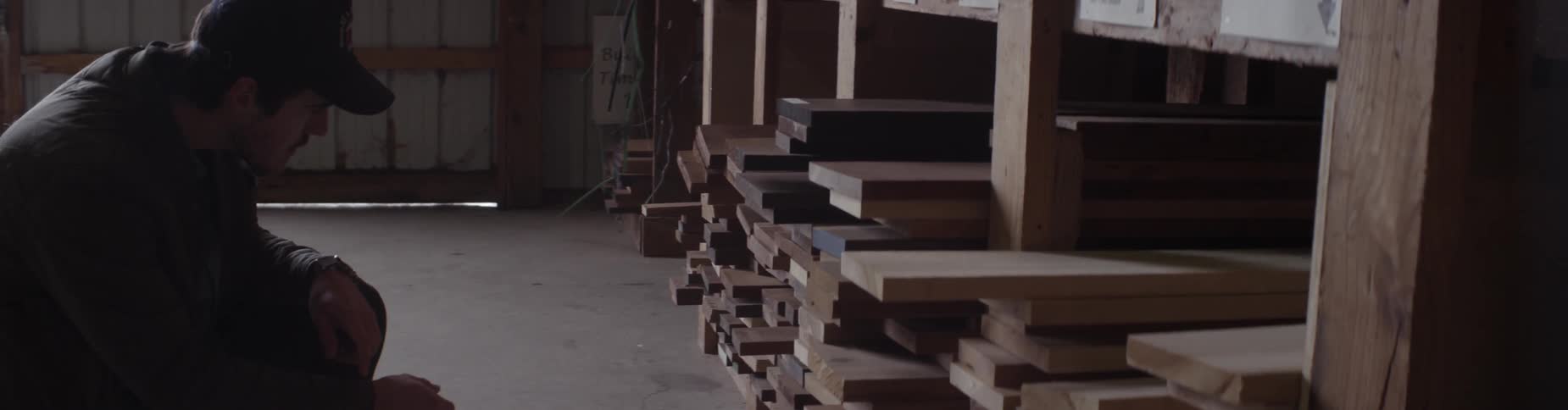A man approaches lumber stacked on shelves