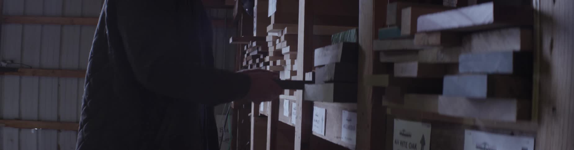 A man pulls a board from the shelf