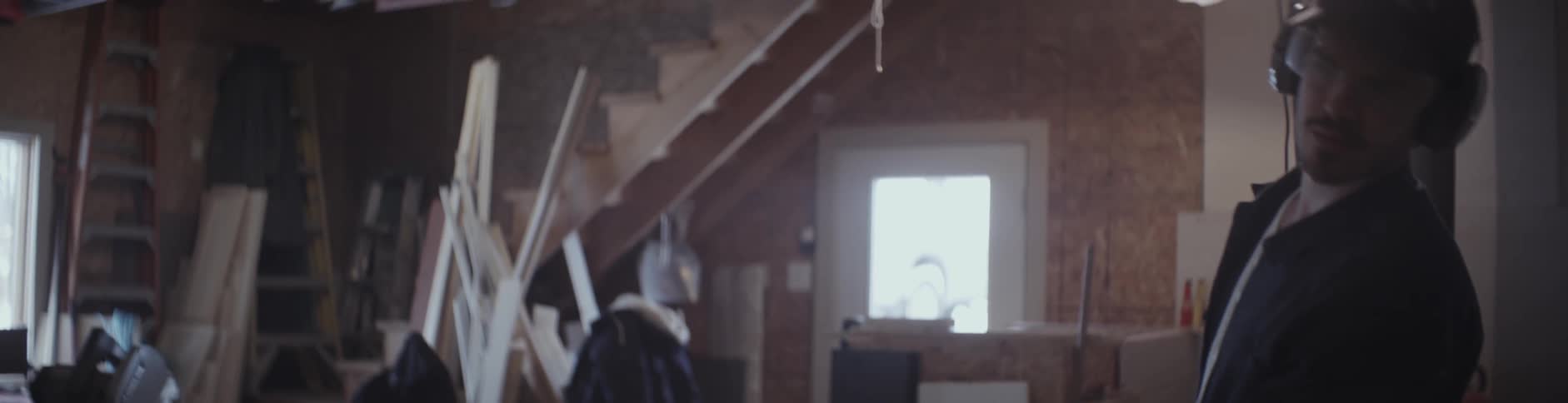 A man feeds a piece of lumber through machinery