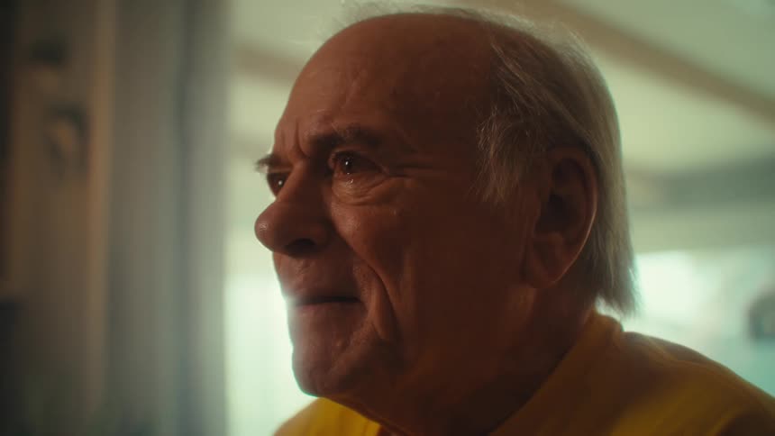 An elderly mans tearfilled eyes captures a powerful moment of emotion and reflection while he writes in a book