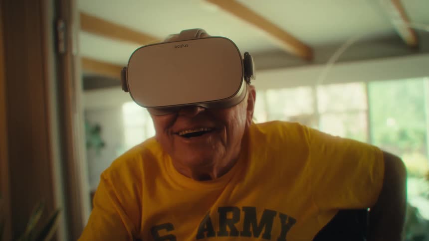 An elderly man uses a vr headset in his living room
