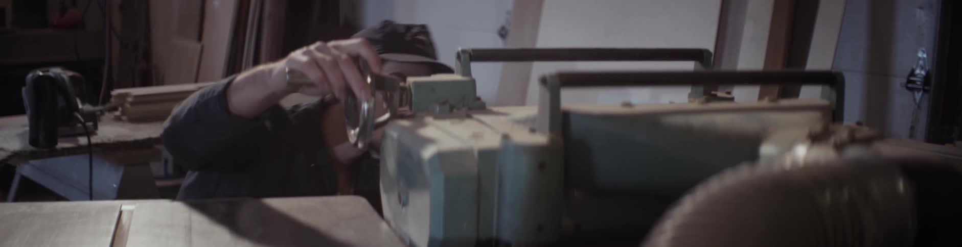A man kneels and examines machinery