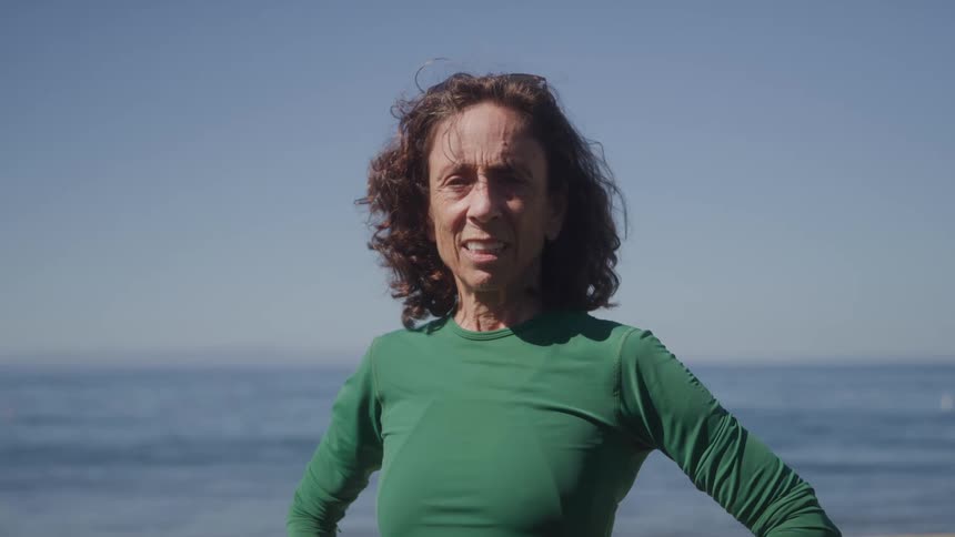 Woman giving a big smile by the ocean