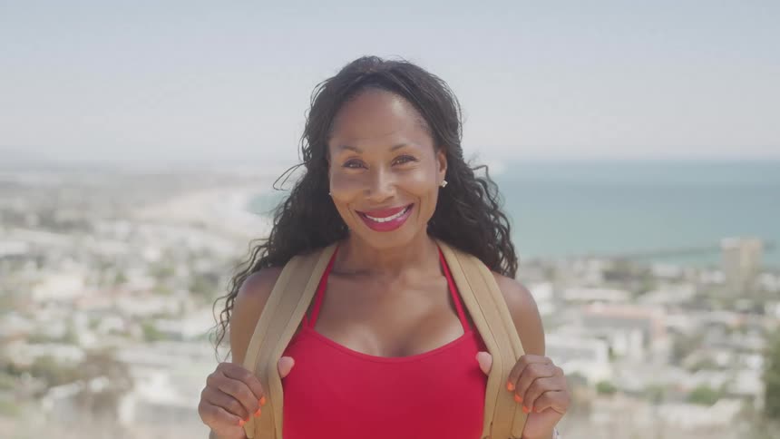A woman in red smiles at the camera