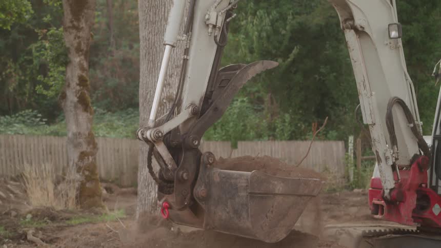 Digging up dirt with a mini excavator on a property