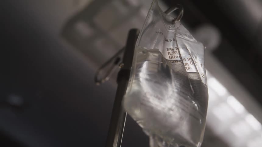 Halffull bag of medication hangs from an iv pole