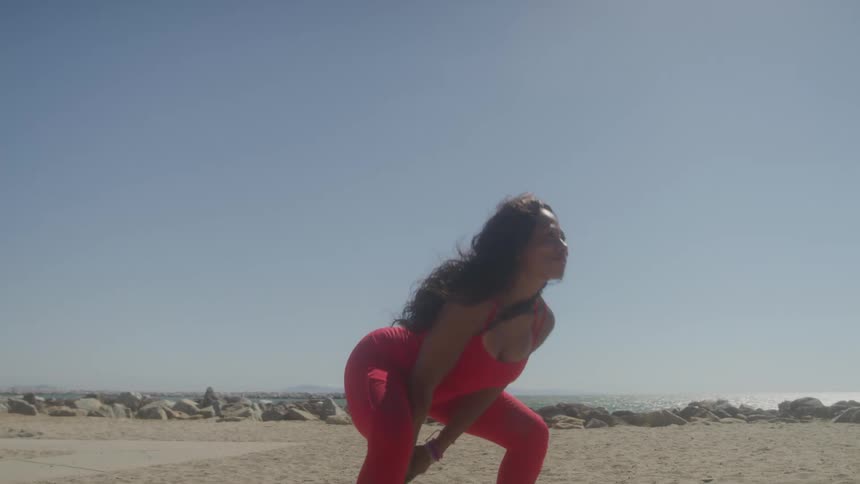 Female doing kettleball swings workout at the beach