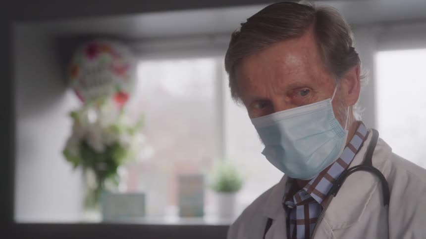 The doctor is talking while wearing a mask