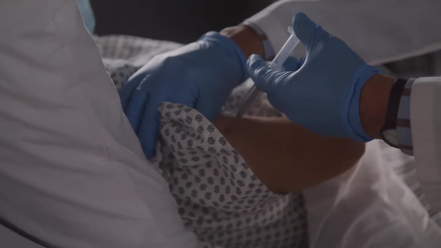 The doctor gives the patient an injection