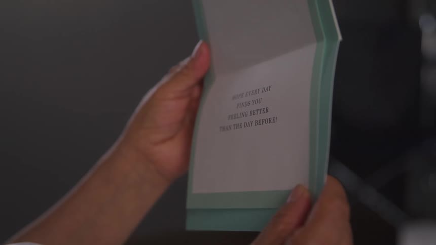 A person is holding a card with a message on it