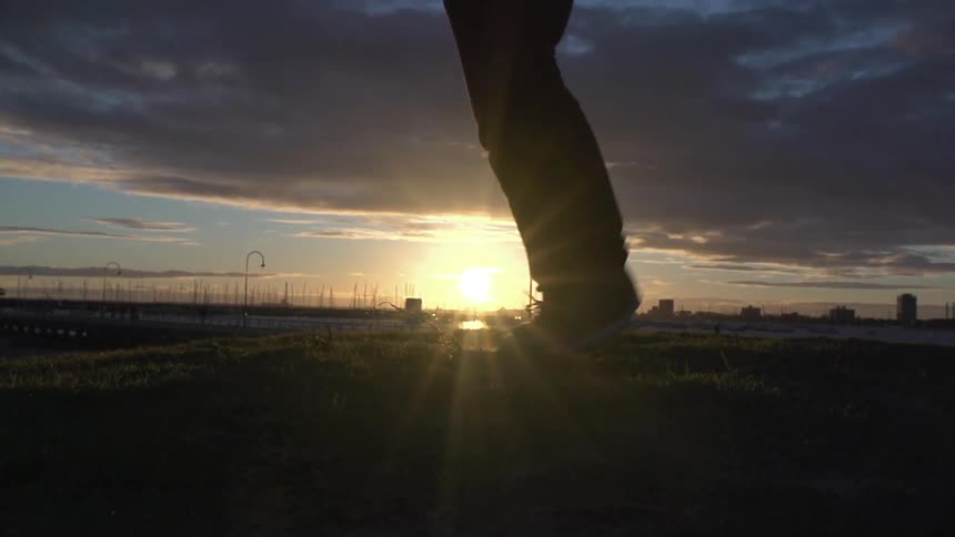 A person dances as the sun sets