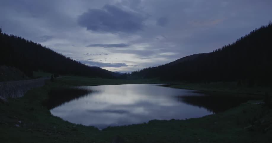 The lake is reflecting the light from the sunset