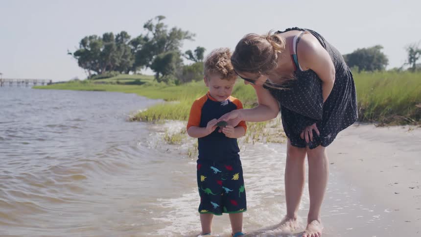 Mother and son enjoy playful time at the water edge