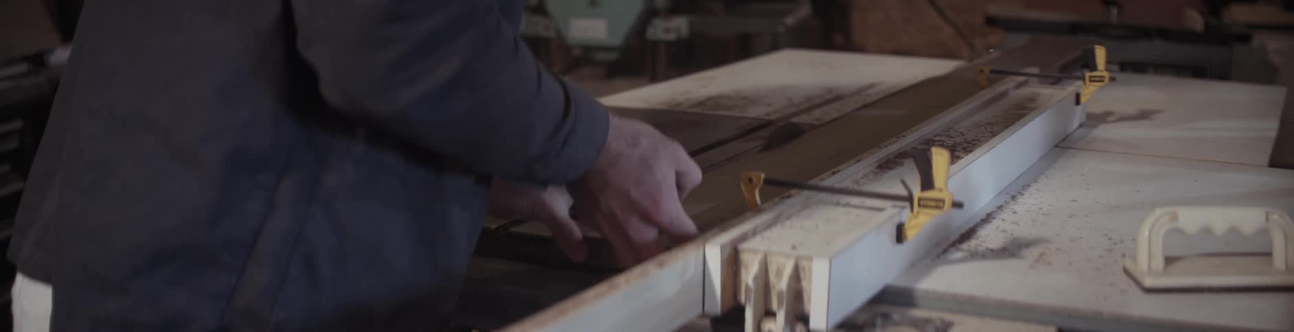 A man is using a machine to measure and cut wood