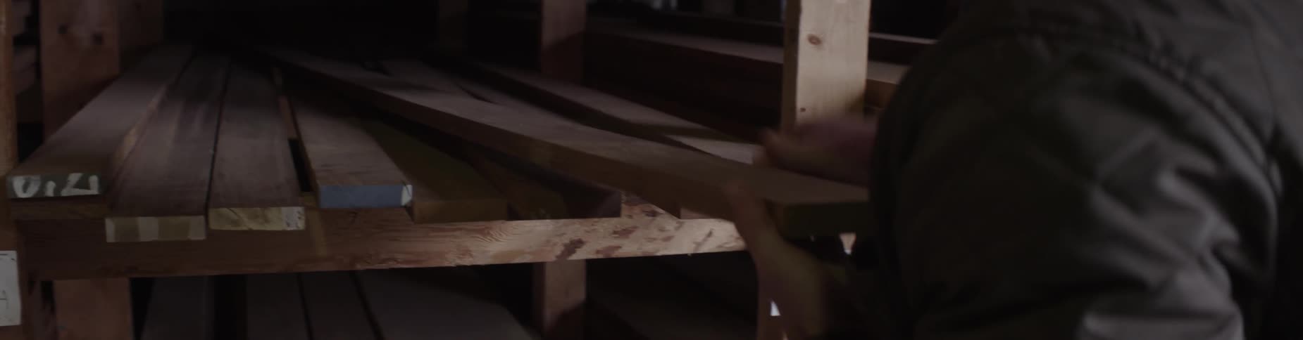 A man inspects pieces of lumber