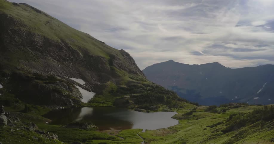 A mountain lake is shown on a cloudy day