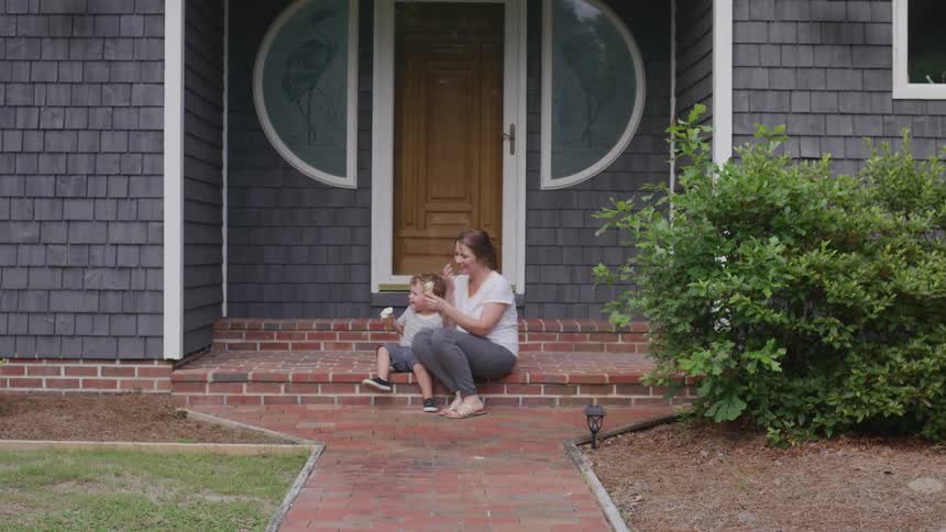 Mother sitting with her little son eating ice cream