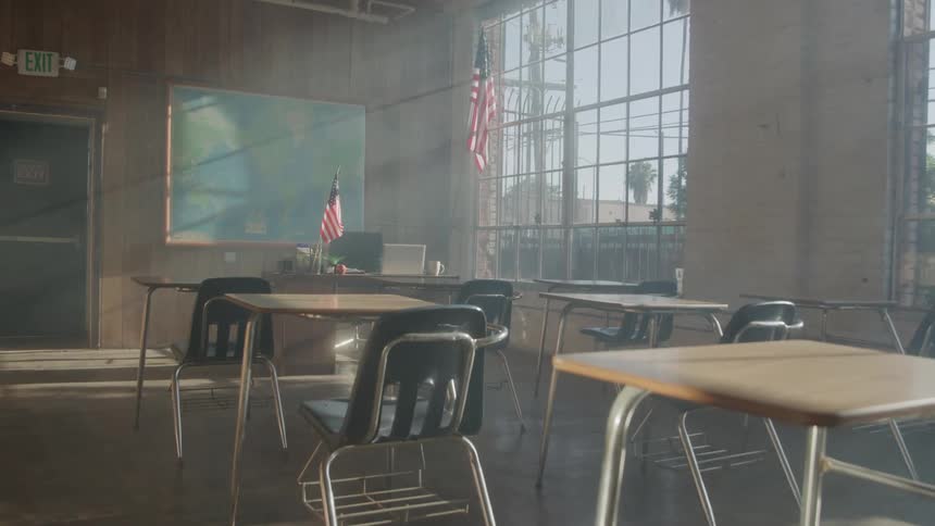 Empty classroom lit by sunlight streaming through the windows