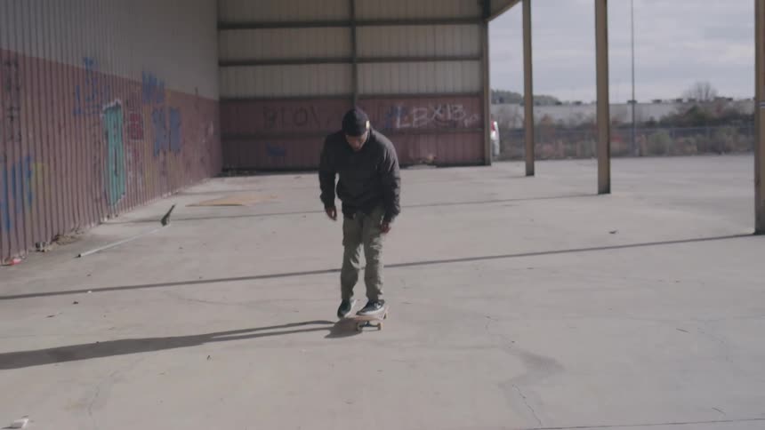 A young black male performs tricks while skateboarding outdoors during daytime
