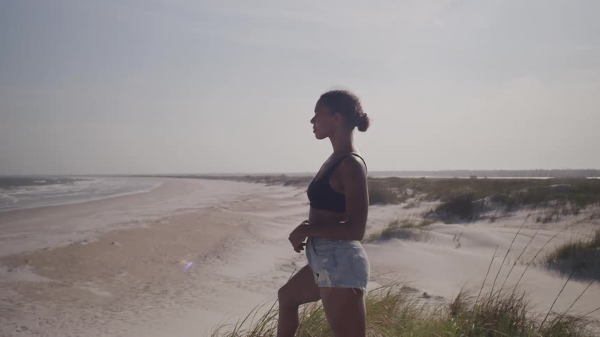 A woman stands on the beach