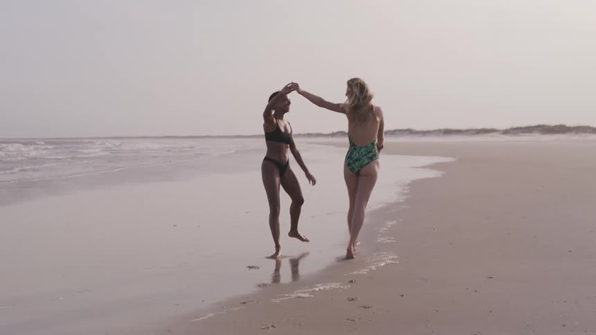 Two friends walk on the beach enjoying their vacation