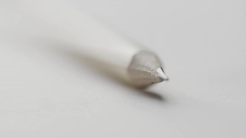 Tip of a graphite pencil in sharp focus with a blurred background