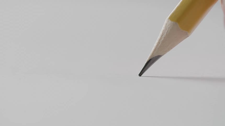 Close up sharpened yellow pencil touching white surface