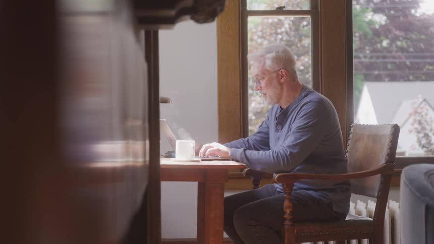 Man sitting typing on a laptop