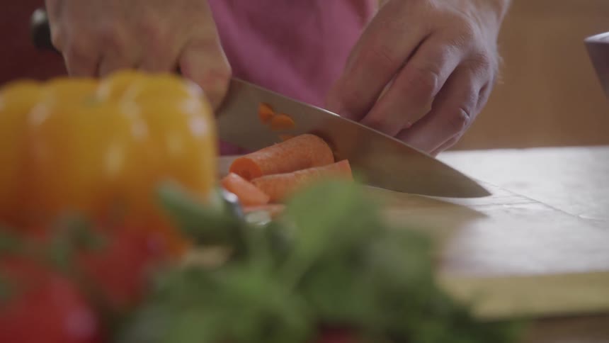 A person slicing up a carrot