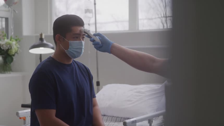 A man takes his patients temperature