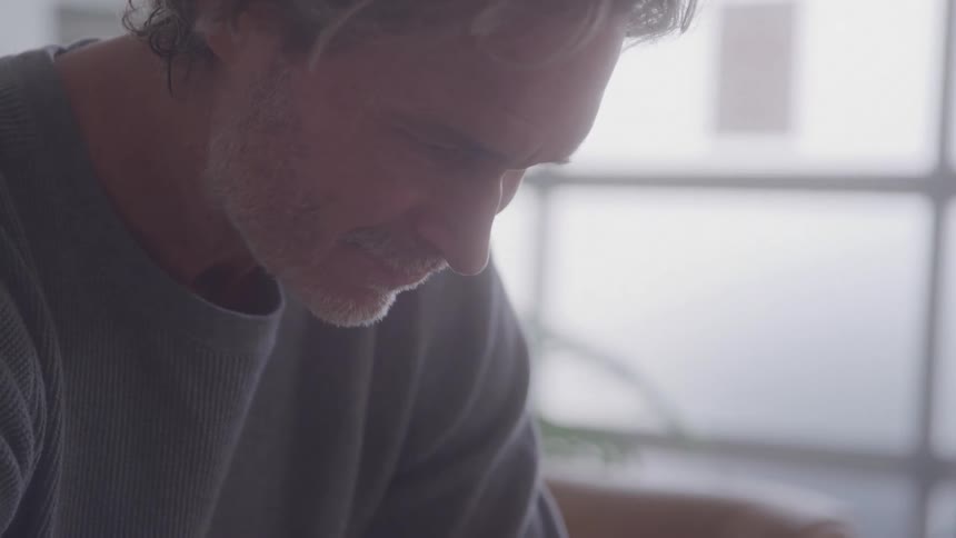 Concentrated white bearded man looking down