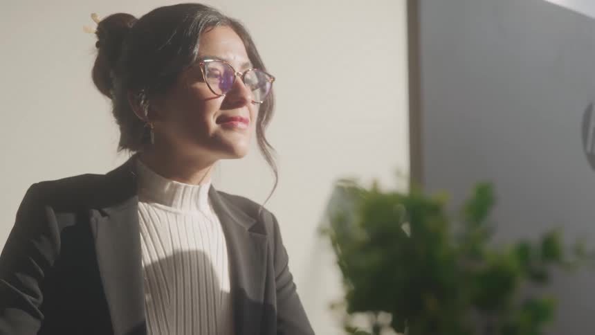 Woman in an indoor space with glasses concentrating