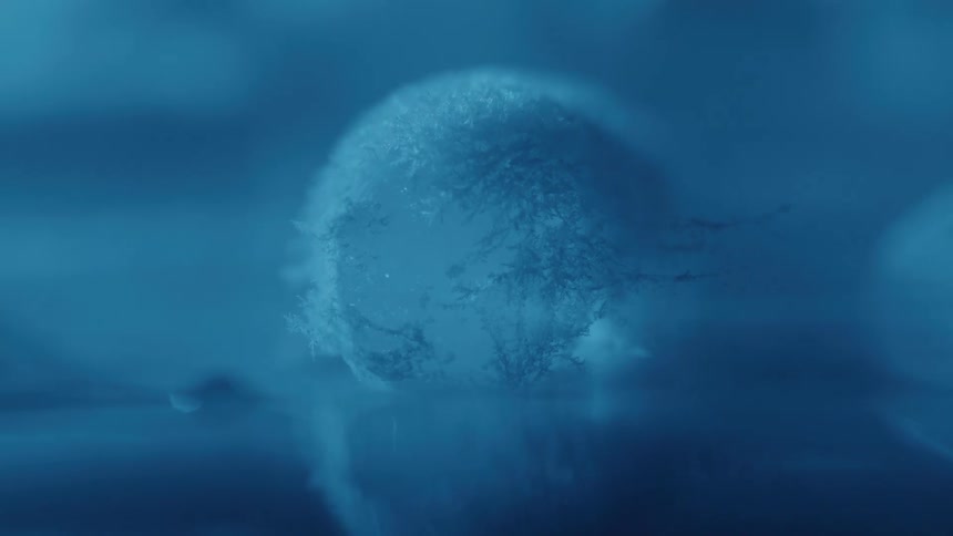 Ice sphere with crystallized patterns reflected on a smooth surface