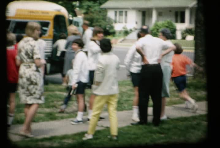 Children and parents are gathered around a bus