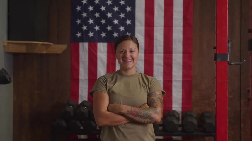 Portrait of a young female military personnel standing in a gym during daytime