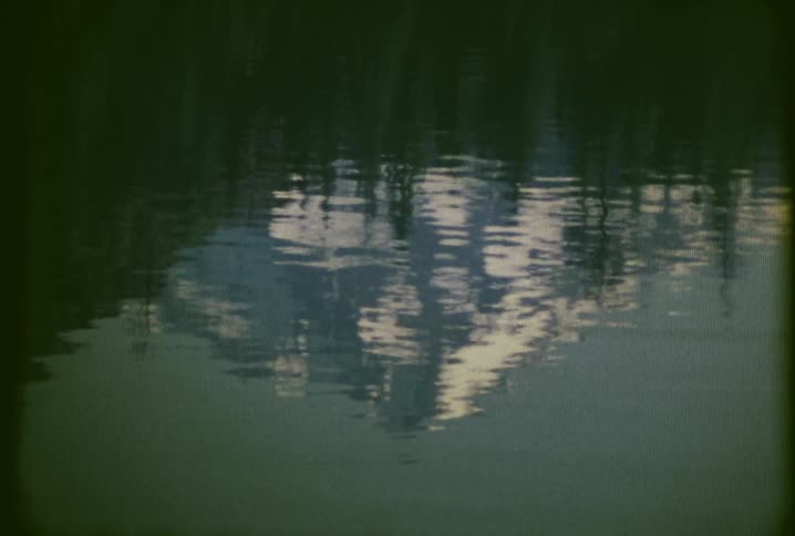 The water is reflecting a mountain below