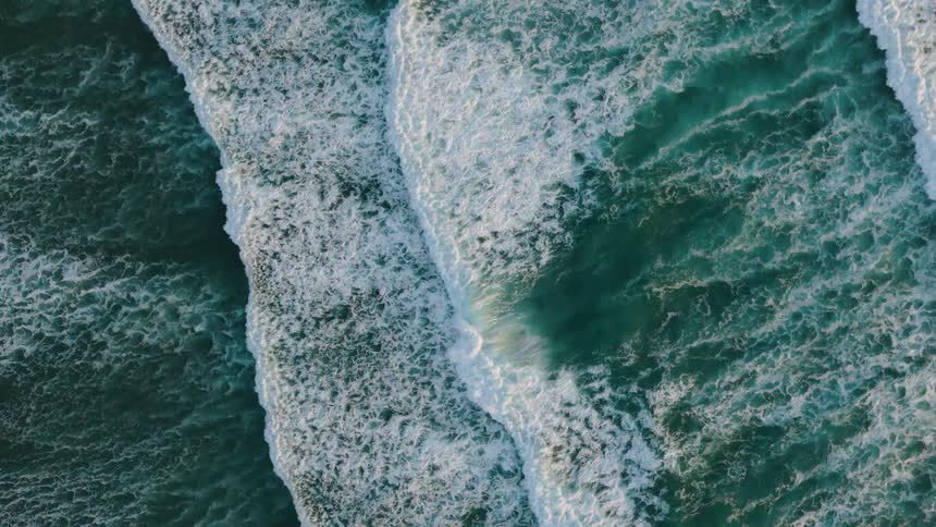 Ocean waves crash forming lines of white foam
