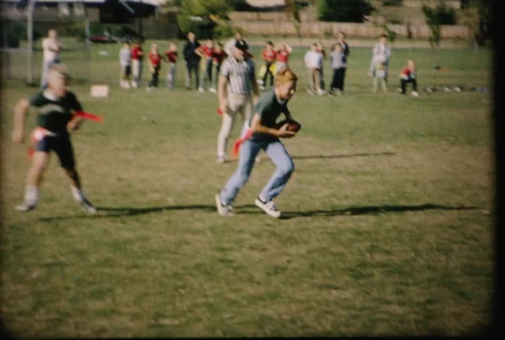 Kids are playing flag football on a field