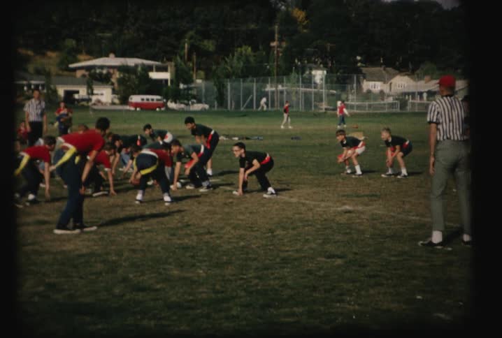 An older film of some boys playing football on a field