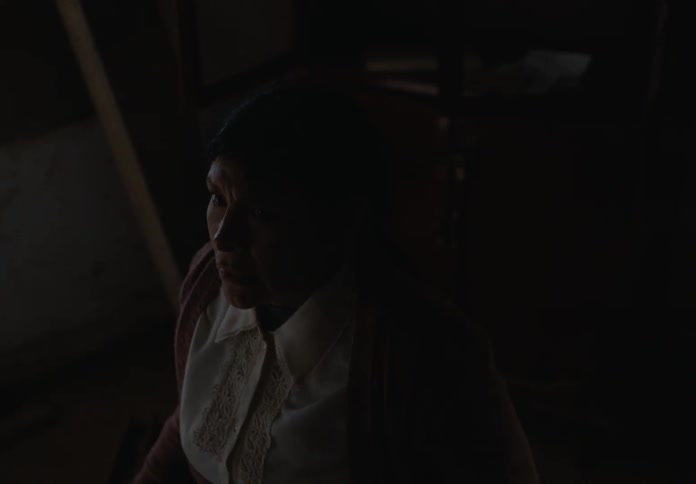 The woman is scared in the very dark room