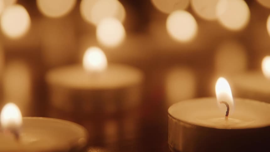 A series of candles are lit each with a yellow flame