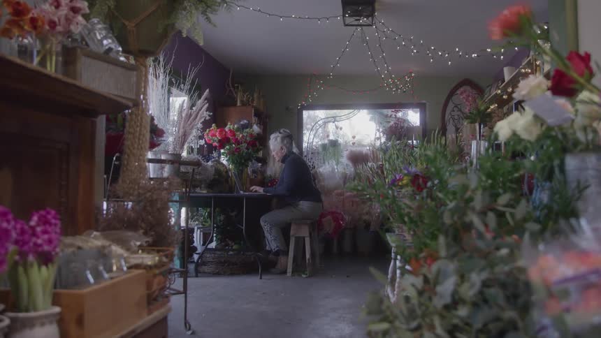 The florist is typing on her keyboard