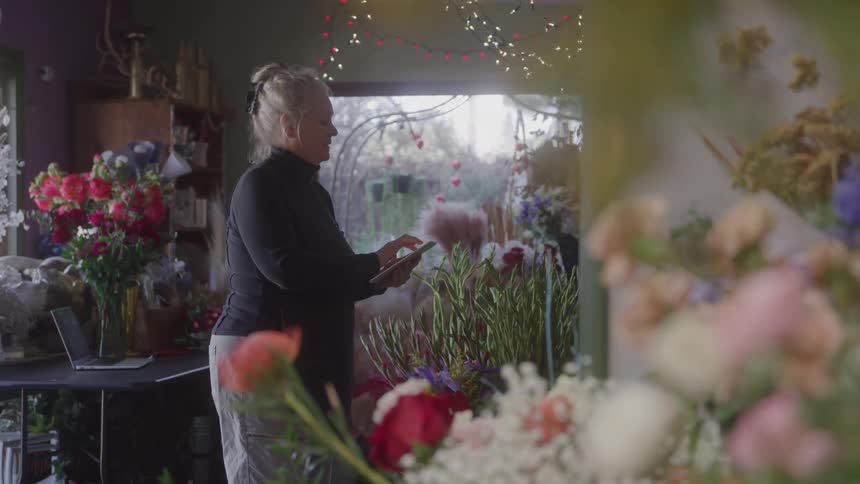 Lady working with a tablet inside a flower shop