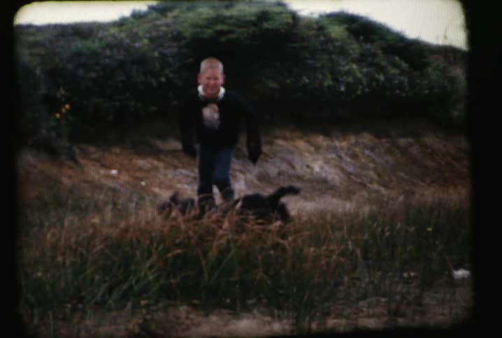 A child runs playfully with a dog